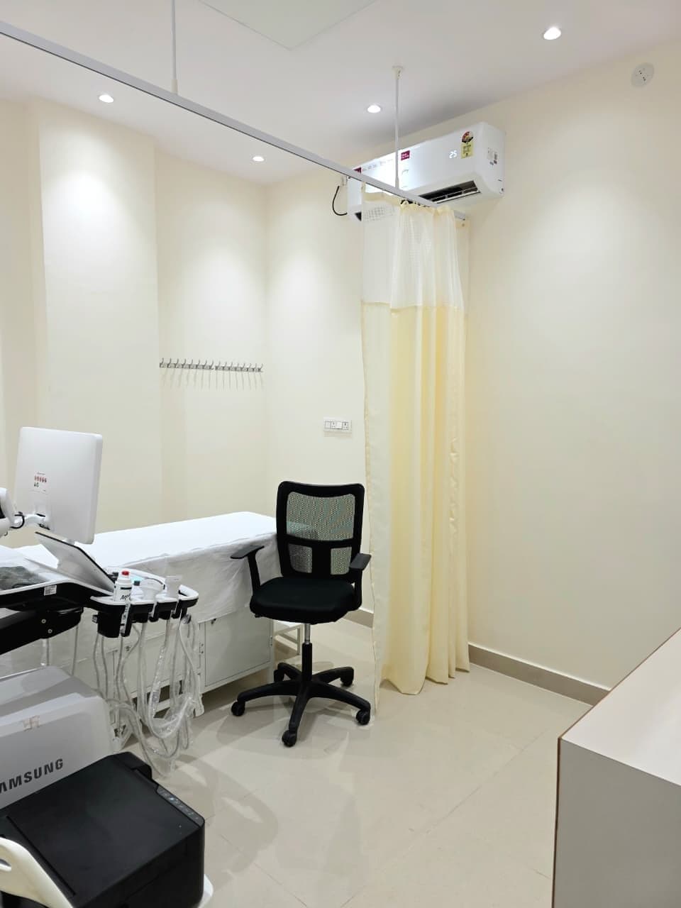 An examination room at DC Scans with a Samsung ultrasound system and privacy curtain